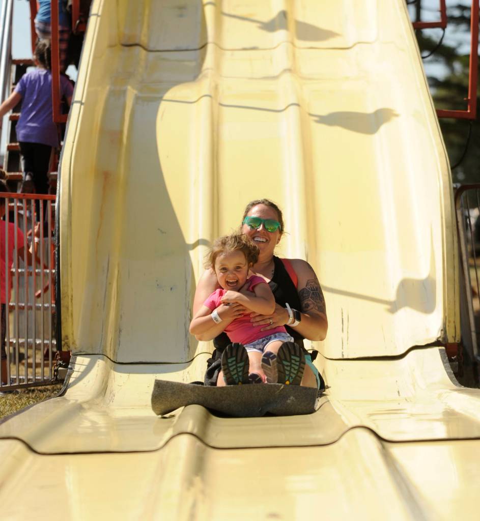 At left, 3-year-old Stormie Trevino, and Stephanie Trevino enjoy multiple rides on a slide at the Clallam County Fair carnival last week.