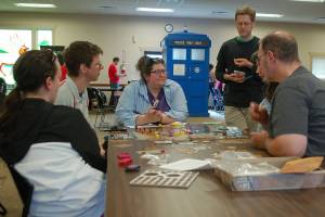 Several people from Sequim and Port Angeles work together to learn a new game at Opttacon 2019 at the Guy Cole Event Center on Aug. 17. Sequim Gazette photo by Conor Dowley