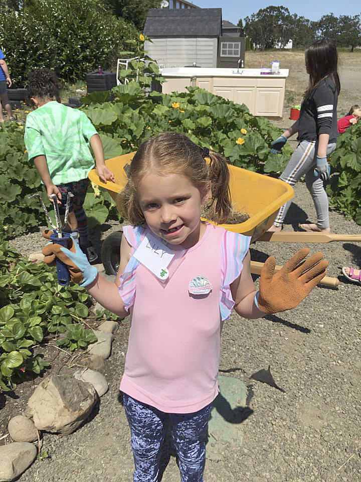 Lily Clark works in the garden along Fir Street at the Sequim Boys & Girls Club last week.