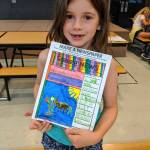 Selene Dorkin shows off her newspaper article during Morning Camp activities at the Sequim Boys & Girls Club last week. Submitted photo