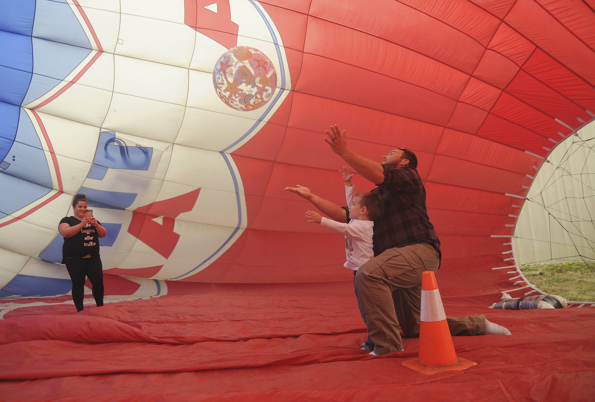 As Amanda Cox takes a photo, and Lukas Cox helps 3-year-old Camden toss an inflated ball in the Morning Star Balloon Co.s bouncy balloon at the 2019 Olympic Peninsula Air Affaire and Sequim Valley Fly-in on Aug. 24. Sequim Gazette photo by Michael Dashiell