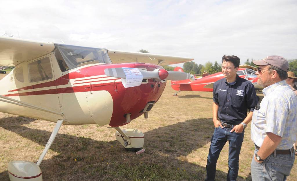 Mark Donahue of Kitsap County, far right, talks with Harrison Shinohara of the Port Townsend Aero Museum as they stand near a 1946 Cessna 140.