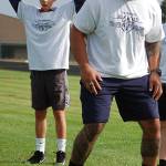 Sequim Middle School student Austin Schilling watches as Wayne Hunter, a former Seattle Seahawks offensive lineman who spent 11 years in the NFL, gives an example on how to properly run an agility ladder drill to a group of attendees of the first annual Sequim Middle School football camp. Sequim Gazette photo by Conor Dowley