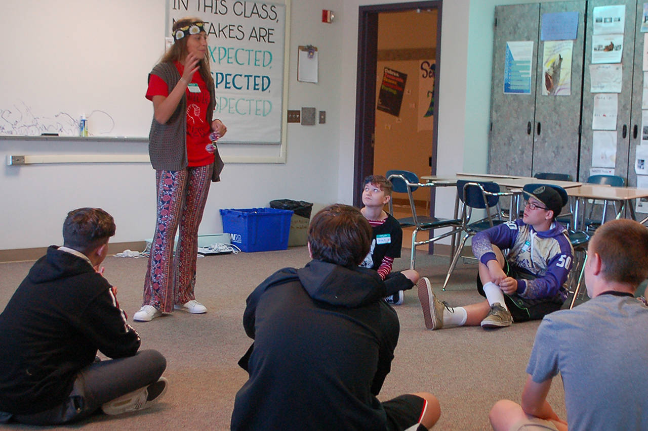Above, Jessica Dietzman, standing, talks with a group of incoming Sequim High School freshmen at a Link Crew orientation on Sept. 3. Dietzman and the other Link Leaders are overseen by SHS teacher Sean OMera and help ease the transition into high school for all the incoming freshmen, with pairs of older students working with small groups of 8-10 freshmen.                                Left, Greywolf Elementary School first grade teacher Kylie Douglas laughs as she puts together supplies on one of her students tables. Douglas is a new teacher at Greywolf, having taught in Tennessee before moving to the area in 2018, but will miss the first two weeks of the school year after undergoing back surgery on Sept. 4. This just reinforces for me that our substitutes are the real heroes of the school district, she said.                                 Below, new Sequim Middle School principal Mark Harris works on a series of posters exemplifying the five core values hes going to be emphasizing at the school this year: respect, integrity, collaboration, perseverance and compassion. These are things that our students need to learn more about at this stage when theyre really starting to want to become adults, Harris said. We want to give them the best examples and reinforcements of these ideas that we can. Sequim Gazette photos by Conor Dowley