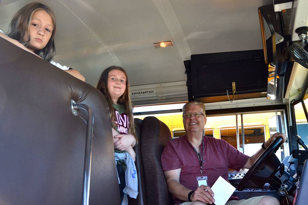 Fourth grader Payton Butler, left, and Hope Hottman, a fifth grader, ready to ride the Minnie Mouse bus driven by Rich Johnson at the end of Sequim School Districts first day of school on Sept. 4. Sequim Gazette photo by Matthew Nash