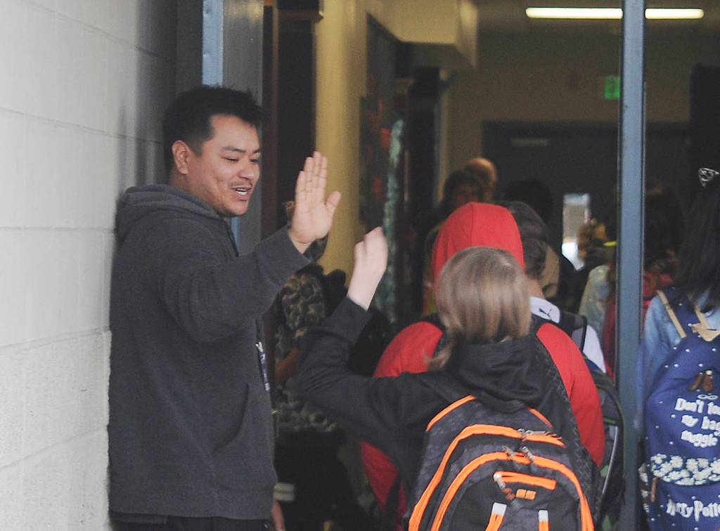 Paraeducator Arnold Black gives high-fives to students at Greywolf Elementary on the first day of school. Sequim Gazette photo by Michael Dashiell