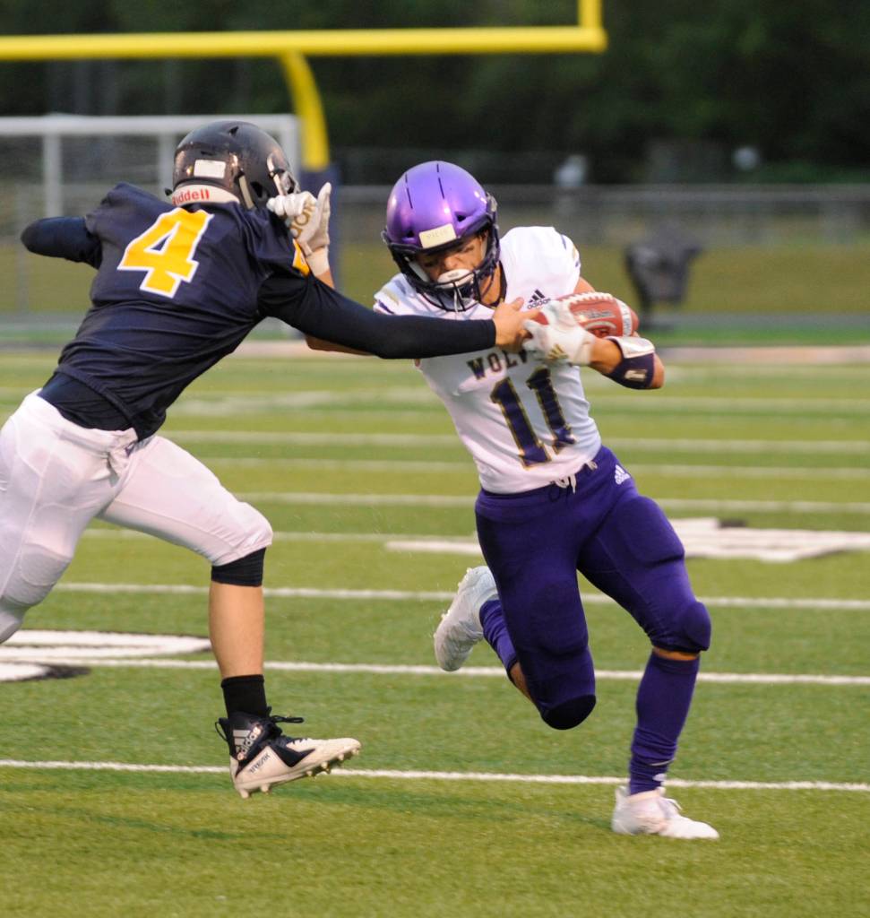 Sequim receiver Michael Young, right, looks to shed the tackle of Forks Carter Windle in the first quarter of the Wolves 27-13 win at Forks on Sept. 13. Sequim Gazette photo by Michael Dashiell