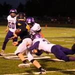 Forks quarterback Carter Windle (4) tries to evade the tackles of Sequims Truman Nestor (foreground) and Lane Mote as Sequims Isaiah Cowan (50) looks on. Sequim Gazette photo by Michael Dashiell