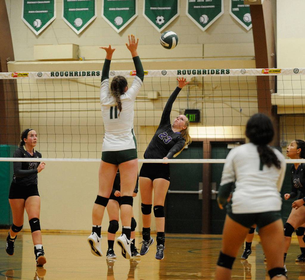 Sequims McKenna Hastings, center, looks to hit the ball past Port Angeles Ava Brenkman in the Wolves five-set loss at Port Angeles on Sept. 12. Sequim Gazette photo by Michael Dashiell