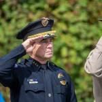 Port Angeles Police Chief Brian Smith salutes as the Grand Olympics Chorus sings the national anthem during a ceremony in Port Angeles honoring public safety officials on the 18th anniversary of the 9/11 terrorist attacks Wednesday. (Jesse Major/Peninsula Daily News)