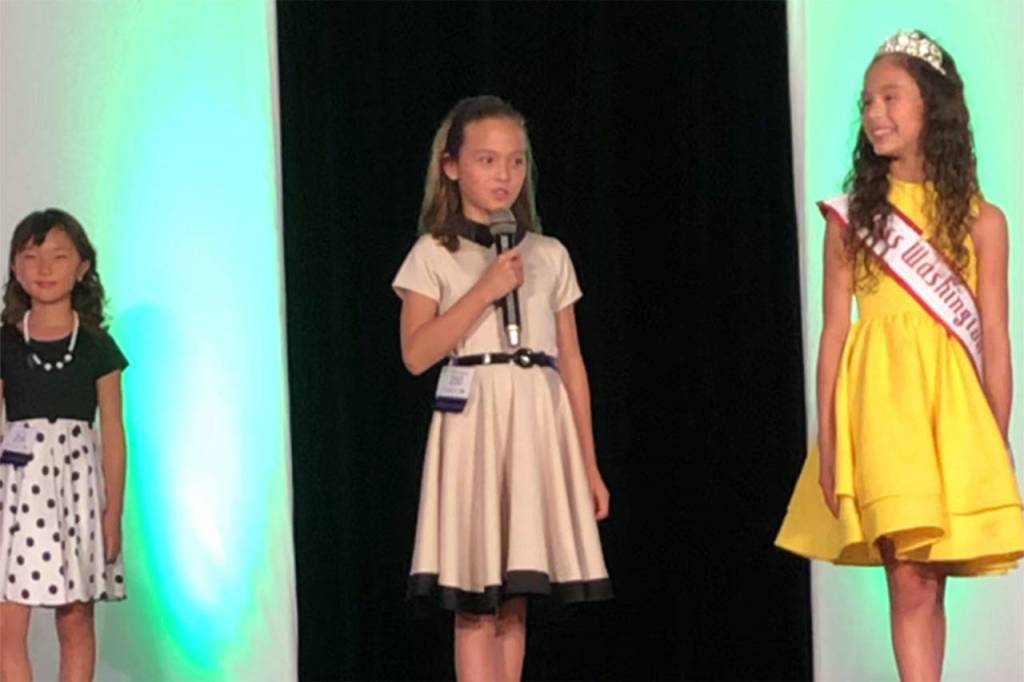 In August, Genevieve Wakefield, 9, introduces herself before judges of the Washington National American Miss pageant. She placed in the top 10, but will compete in the All-American pageant. Photo courtesy of Lula Wakefield