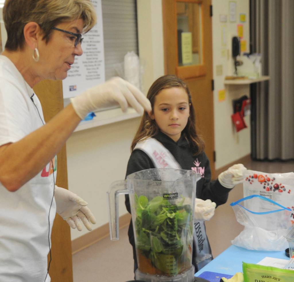 Dr. Monica Dixon gets some help from young Genevieve Wakefield as they demonstrate and prepare healthy smoothies at the Dungeness Valley Health & Wellness Clinic health fair on Sept. 14. See story on Page 14. Sequim Gazette photo by Michael Dashiell