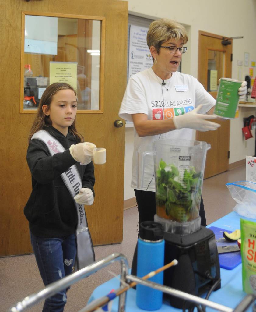 Dr. Monica Dixon gets some help from young Genevieve Wakefield as they demonstrate and prepare healthy smoothies at the Dungeness Valley Health & Wellness Clinic health fair on Sept. 14. Sequim Gazette photo by Michael Dashiell