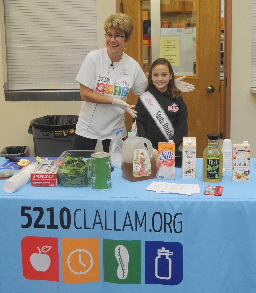 Dr. Monica Dixon gets some help from young Genevieve Wakefield as they demonstrate and prepare healthy smoothies at the Dungeness Valley Health & Wellness Clinic health fair on Sept. 14. Sequim Gazette photo by Michael Dashiell