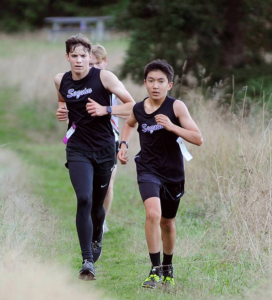 Sequims Kaleb Needoba, Left, and Koda Robinson race in a league meet against Olympic and Port Townsend on Sept. 18. Needoba placed fifth and Robinson sixth; the pair less than just four-tenths of a second apart. Sequim Gazette photo by Michael Dashiell