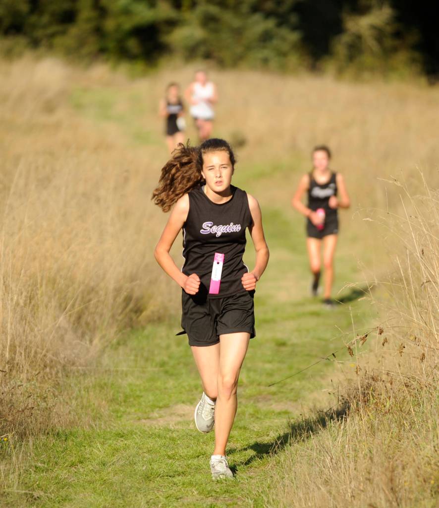 Sequim freshman Anastasia Updike races up Meadow Hill at Robin Hill County Park on Sept. 18. Updike went on to finish fourth overall, completing the hilly, 3.1-mile course in 25:13. Sequim Gazette photo by Michael Dashiell