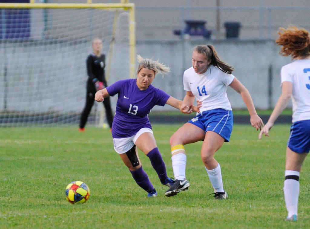As goalkeeper Olivia Hare, background, looks on, Sequim junior midfielder Natalya James, left, vies for the ball with Bremertons Claire Warthen in the Wolves 4-1 home win over Bremerton on Sept. 17. Sequim Gazette photo by Michael Dashiell