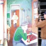 A crew member from Seattle-based Artech, contracted by the Sequim-Dungeness Valley of Commerce to help remove part of the Lehmans mural in March of 2002. Sequim Gazette file photo by Jeff Chew