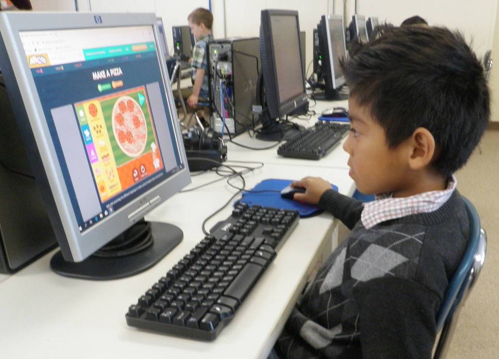 Kindergartener Andres Yescas selects toppings for his virtual pizza by clicking and dragging the mouseimportant movements for honing basic computer skills. Photo by Patsene Dashiell