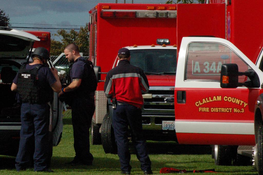 Members of the Clallam Fire District 3 Rescue Task Force prepare for the Criminal Mass Casualty Incident drill at Sequim Middle School on Sept. 28. The RTF uses paramedics in the same kind of tactical protective gear used by police being escorted by officers into potentially insecure areas during a shooting or other similar incident in order to more quickly reach, triage and begin treatment on victims of the incident. Sequim Gazette photo by Conor Dowley