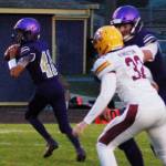 Sequim Wolves quarterback Kobe Applegate (11, left) drops back to pass as Brandon Barnett (right, obscured) blocks Kingston lineman Dylan Baze (32). Applegate started slow, but came back to complete 10 of 19 passes with two touchdowns, both to Michael Young in the second half of the Wolves 44-14 Homecoming win over Kingston on Oct. 4. Sequim Gazette photo by Conor Dowley