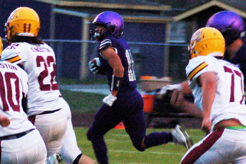 Michael Young, center, looks for the corner on a first quarter run against the Kingston Buccaneers on Oct. 4. Young would put up 109 yards of total offense, with two receiving touchdowns and one rushing touchdown to help Sequim secure a big Homecoming win over the Buccaneers, 44-14. Sequim Gazette photo by Conor Dowley
