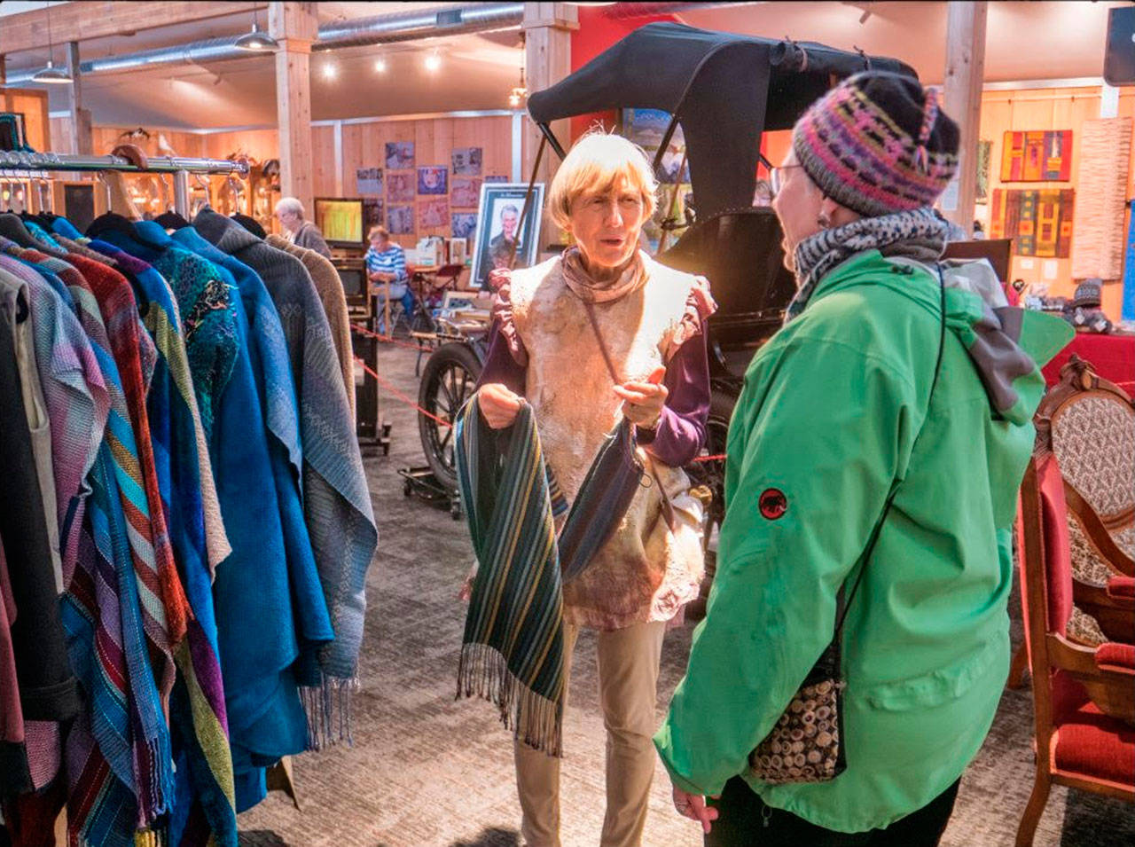 Vendor Jan Tatom of Sequim offers some of her hand-made products to a visitor at the 14th-annual North Olympic Fiber Arts Festival, held at Sequim Museum & Arts last weekend. Photo by Bob Lampert