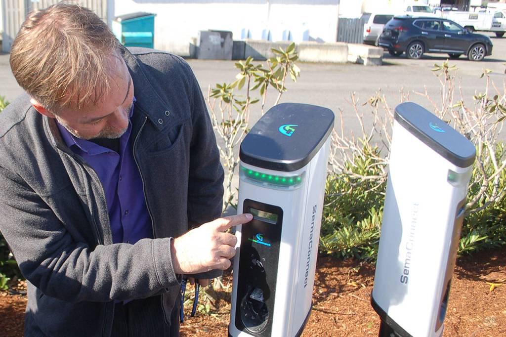 SemaConnect representative Eric Smith shows a gathering crowd how different elements work on the chargers installed at the citys new electric vehicle charging station at the old PUD substation at 410 E. Washington St. on Oct. 11. Sequim Gazette photos by Conor Dowley