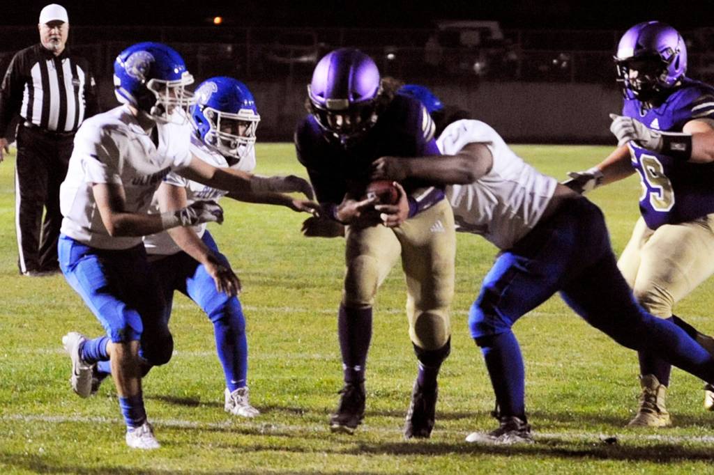 Taig Wiker (center) breaks through the line to score the Sequim Wolves second touchdown of the night during their 37-14 win over the Olympic Trojans on Oct. 11. In the junior quarterbacks first action after missing a game and a half with a knee injury, Wiker threw for 170 yards and three touchdowns, and added 13 more rushing yards and a touchdown on 9 carries. Below, Sequim junior wide receiver Michael Young celebrates as he crosses the goal line to score a touchdown on the Wolves first drive of the game. Sequim Gazette photos by Conor Dowley