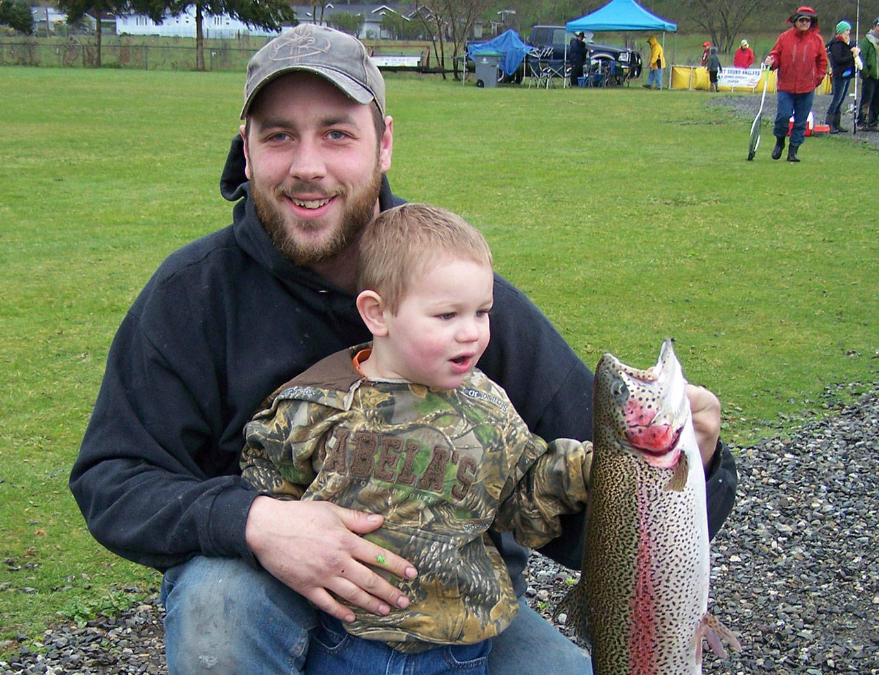 Kyle Helland and his son Everett celebrate a catch of a rainbow trout at the pond just north of Carrie Blake Community Park in April. Photo courtesy of Puget Sound Anglers-North Olympic Peninsula Chapter