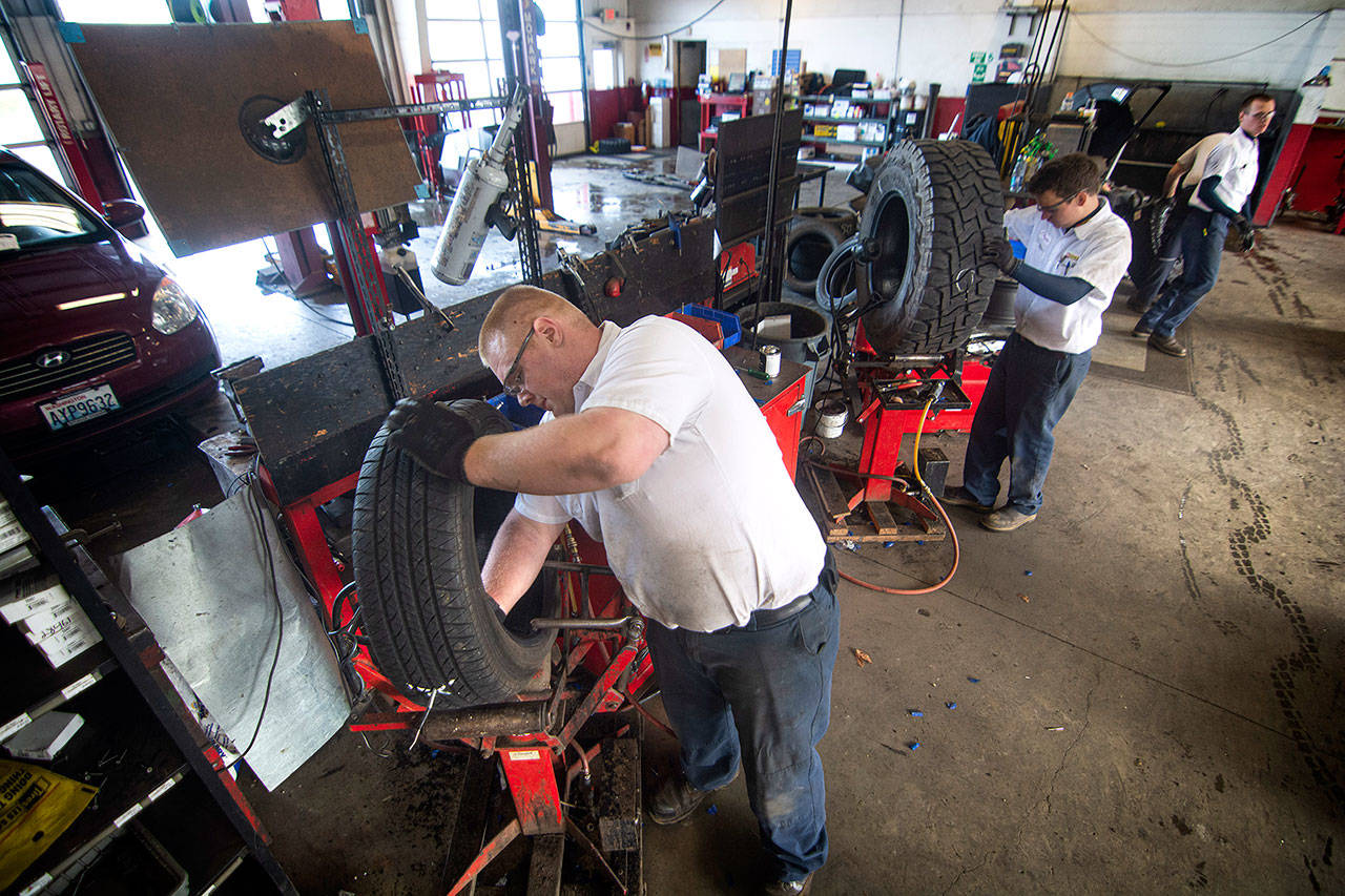 Zach Bucklin repairs a tire at Les Schwab in Port Angeles last week after about customers reported picking up screws in their tires on U.S. Highway 101 at Morse Creek. Photo by Jesse Major/Peninsula Daily News