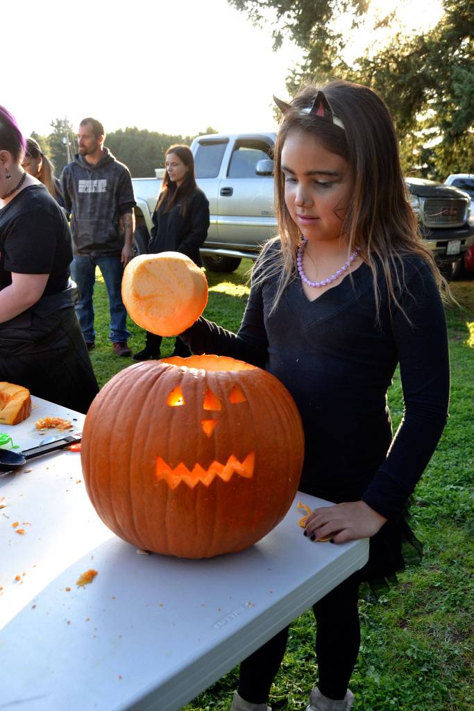 Sahara Jimmy, 8, sees the sun enlighten her recently carved pumpkin at the Sequim Prairie Granges pumpkin party. Sequim Gazette photo by Matthew Nash
