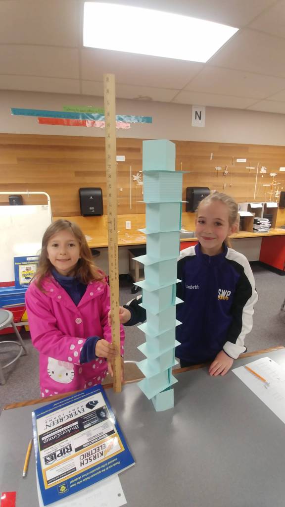 Helen Haller third-graders Annie Sorensen, left, and Elizabeth Grimes measure the height of their index card tower. Photo by Kieth Lee