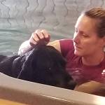 Jennifer Paul works with a black lab named Molly during a canine hydrotherapy session at Swim Doggie Swim. Paul would help Molly get around the pool, and pause periodically to massage areas on her legs, hips and back that were bothering her thanks to a previous leg issue. Sequim Gazette photo by Conor Dowley