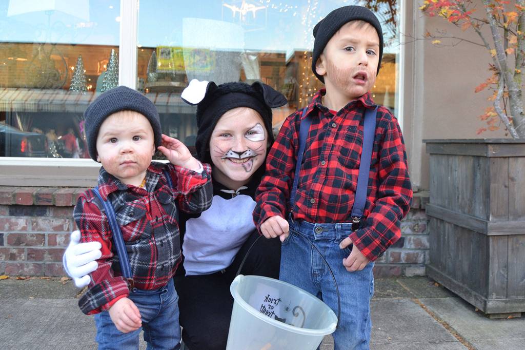 Friendly puppy and older sister Haylee Noel, 10 leads her lumberjack brothers Merritt, 18 months, and Judah, 5, to trick or treat downtown Sequim on Halloween. Sequim Gazette photo by Matthew Nash