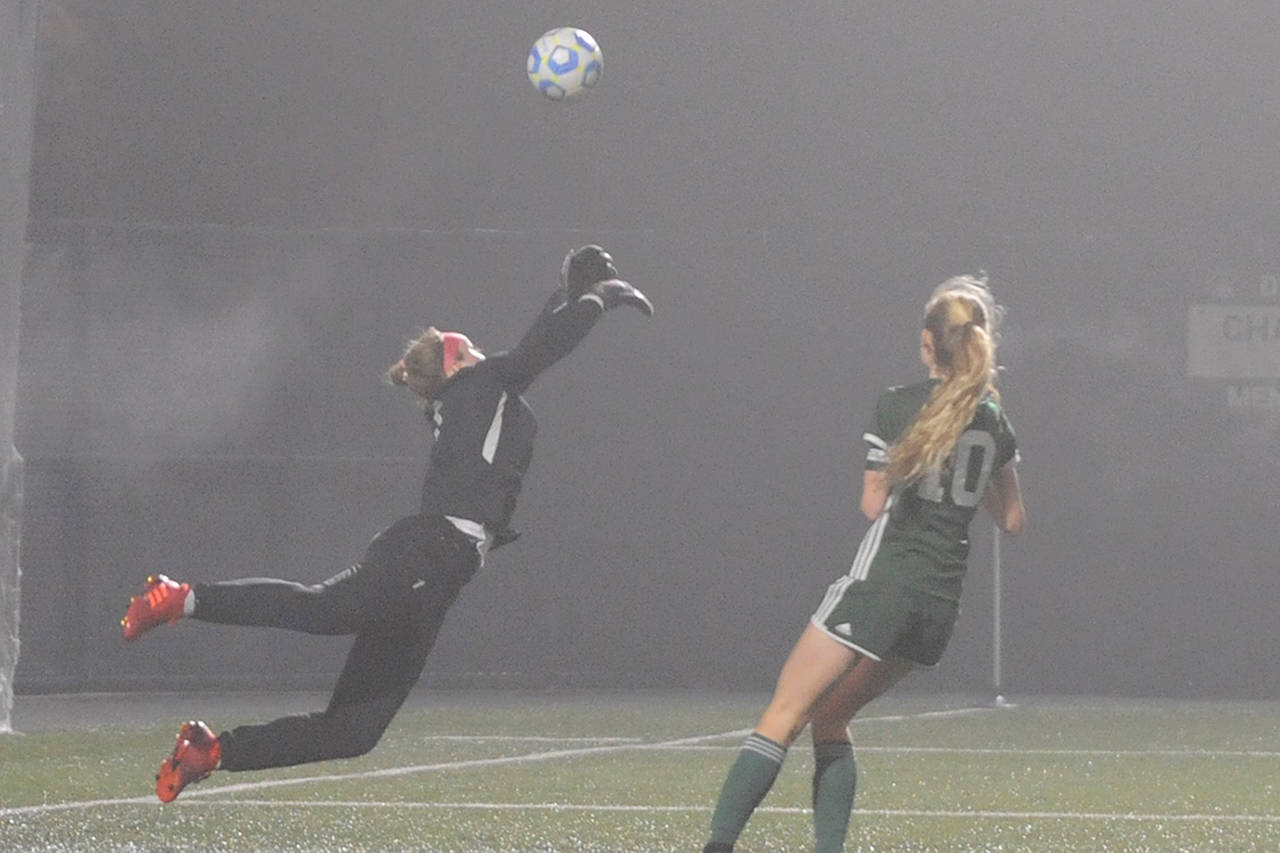 Sequim Wolves goalkeeper Olivia Hale (left) parries a long shot away while Port Angeles Roughriders star Millie Long (right, 10) lurks near goal during their District 3 playoff tournament match at Peninsula College on Nov. 9. Port Angeles won 1-0 thanks to a goal from Long, but the Wolves had already qualified for the 2A state playoffs. Sequim Gazette photo by Conor Dowley