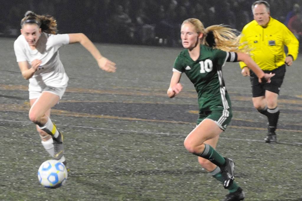 Port Angeles Roughriders forward Millie Long (right, 10) runs on the ball while Sequim Wolves midfielder Abby Schroeder (left) chases her down in the first half of their District 3 playoff tournament match at Peninsula College on Nov. 9. Sequim Gazette photo by Conor Dowley
