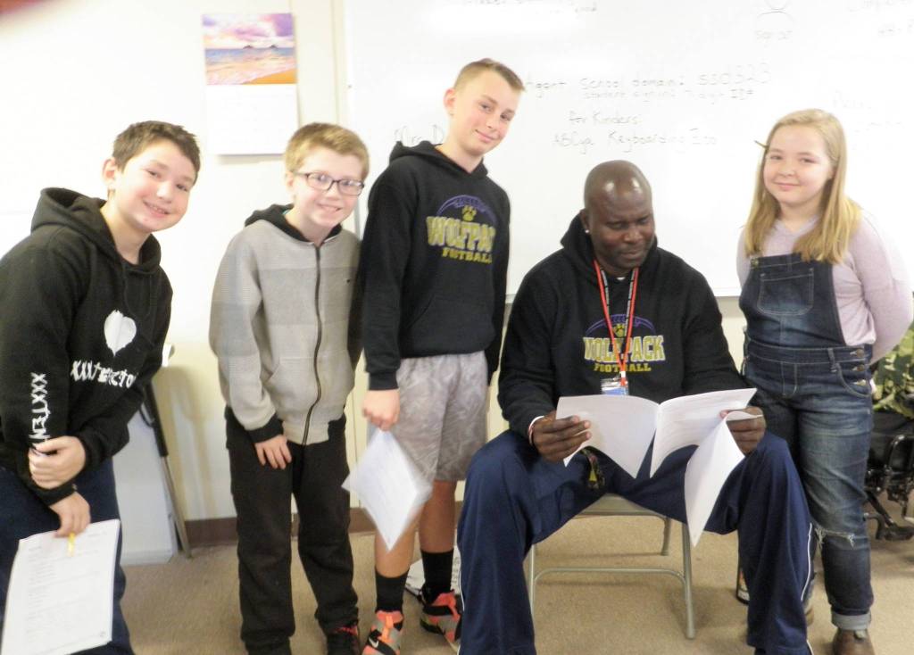 Fifth-graders at Helen Haller take a written fitness test as part of state learning requirements for physical education. From Meredith Vincents class are, from left, Gage Reynolds, Colby Verdu, Ryan Weidman, P.E. teacher Joclin Julmist and Leila Sanderson. Photo by Patsene Dashiell