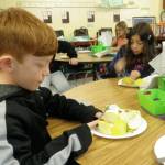 Second-graders Austin Price and Edyn Samudio cut apples into small pieces to be cooked and processed into applesauce in Renee Mullikins classroom at Helen Haller Elementary School. Photo by Patsene Dashiell