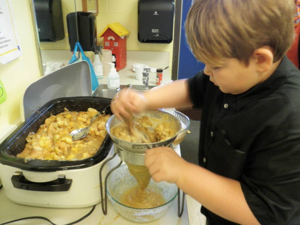 Second-grader Liam Bower processes cooked apple pieces through a food mill to make delicious applesauce in Renee Mullikins classroom. The apples were provided by Clallam Gleaner Kathy Strozyk. Photo by Patsene Dashiell