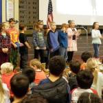Doreen Minards second-grade class at Helen Haller Elementary performs sign language during the tribute song, Thank You, Soldiers, led by ASL Interpreter Janelle Hankinson during the first Veterans Day assembly on Nov. 8. Photo by Patsene Dashiell