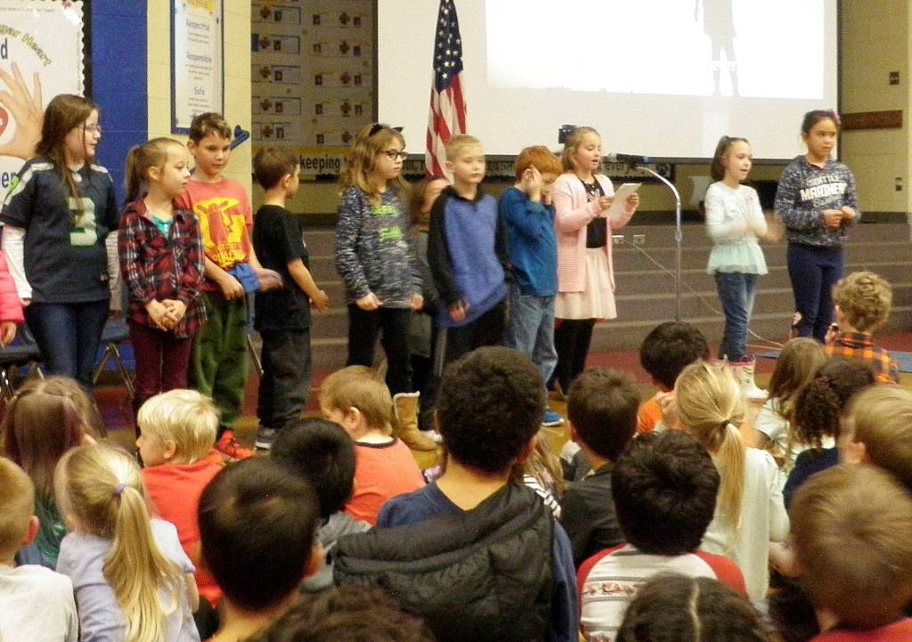 Doreen Minards second-grade class at Helen Haller Elementary performs sign language during the tribute song, Thank You, Soldiers, led by ASL Interpreter Janelle Hankinson during the first Veterans Day assembly on Nov. 8. Photo by Patsene Dashiell