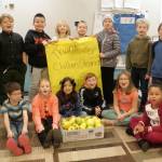 Above, Renee Mullikins second-graders at Helen Haller Elementary are appreciative of receiving apples gleaned and delivered by Clallam Gleaner Kathy Strozyk. The class cut apples into pieces, slow-cooked them and pushed the cooked apple through a food mill to make applesauce. Left, second-graders Austin Price and Edyn Samudio cut apples into small pieces. Photos by Patsene Dashiell