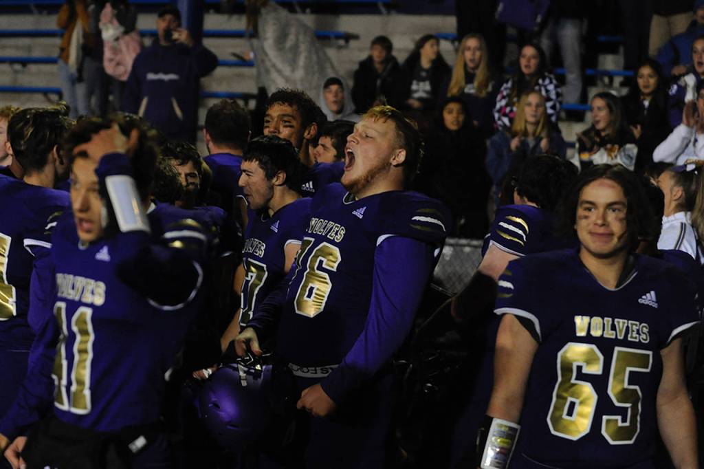 Seth Wilson (76) and other Sequim Wolves players celebrate with fans after their 37-21 district playoff win over the River Ridge Hawks on Nov. 8 to qualify for the 2A state playoffs for the second year in a row. Sequim Gazette photos by Conor Dowley