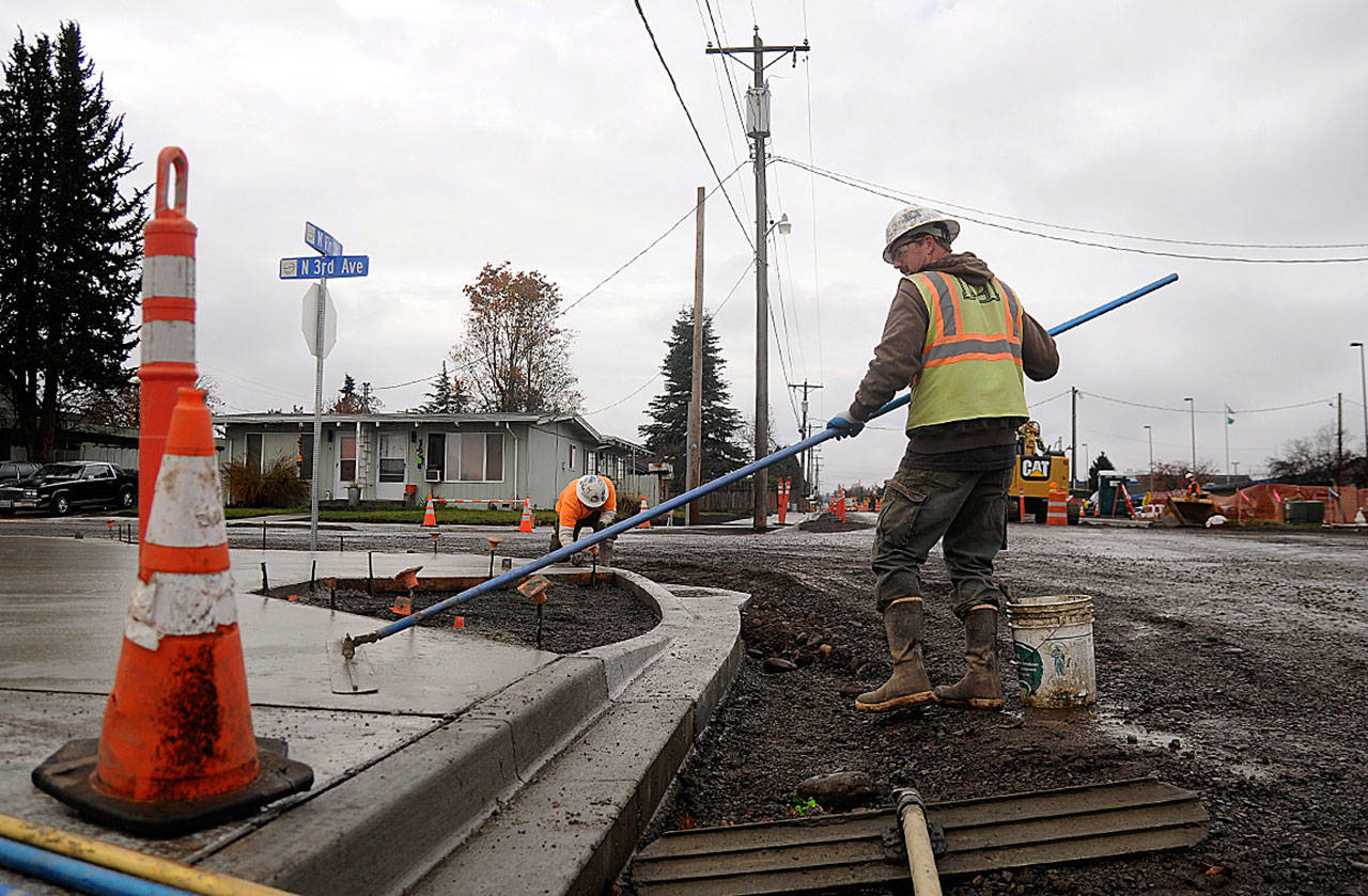 Tim Coville, foreground, and Peter Gish work on sidewalks along West Fir Street on nov. 12. The citys biggest current project at $3.4 million, the projects completion is tentatively slated for late spring, city staff said. Sequim gazette photo by Michael Dashiell