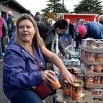 Amy Jo Bolon with Trinity United Methodist Church helps pass out yams on Nov. 19 to volunteers as they prepared bags for families during Thanksgiving. Sequim Gazette photo by Matthew Nash