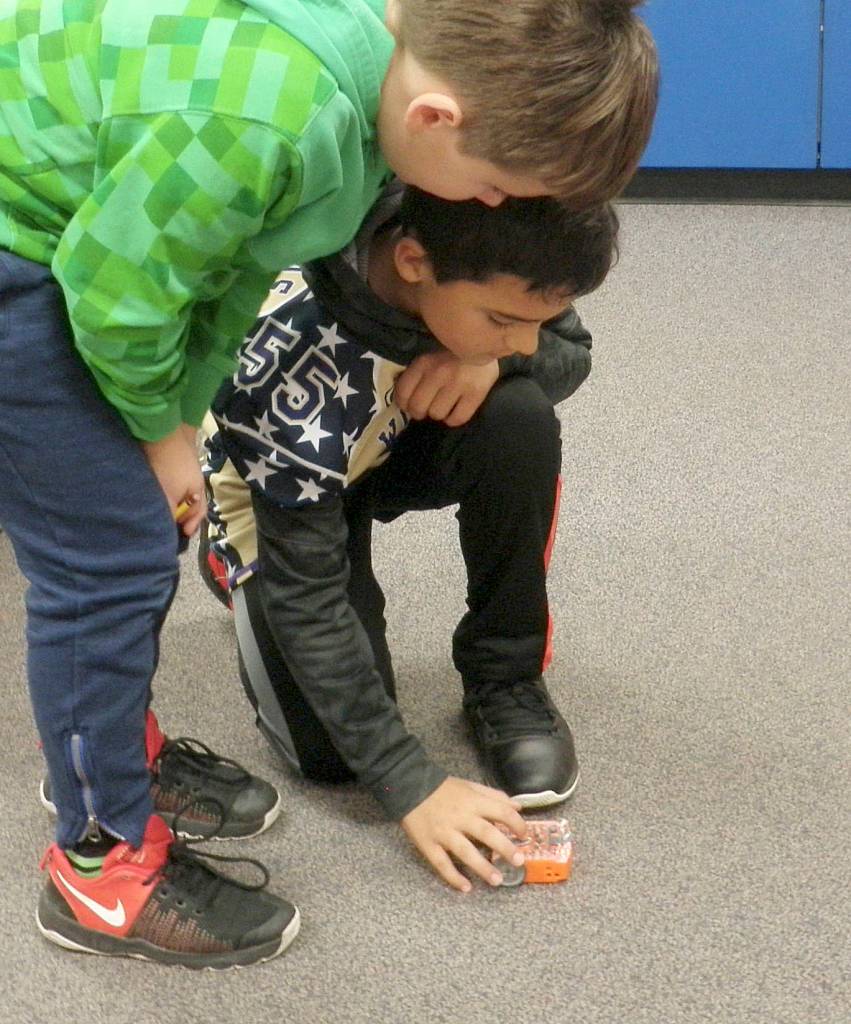 Aidan Coonelly, left, and Ryker Gradillas, fourth-graders in Jesse Klingers class, familiarize themselves with all the Bots movements. Photo by Patsene Dashiell