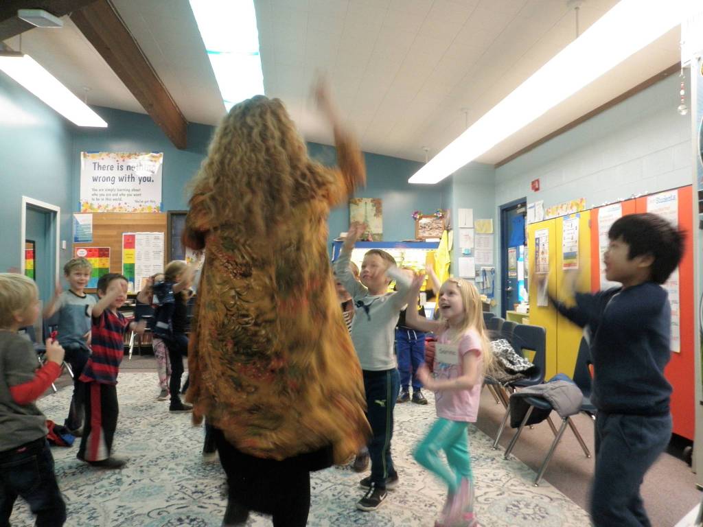 Social Emotional Learning Specialist Marie Claire Bernards engages Kindergarteners from Lorrie Corders class with a classroom activity in Success Academy. We are climbing up a tree to pick fruit, says Bernards. What kinds of fruit are we picking today? Photo by Patsene Dashiell