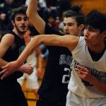 Freshman forward Isaiah Moore, second from right, passes the ball out from under the basket while under pressure from Klahowya Eagles forward Deven Patch during the Sequim Wolves 45-37 win over the Eagles on Dec. 2. Moore had eight points, eight rebounds and two blocks in his first high school game. Sequim Gazette photo by Conor Dowley