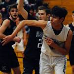 Freshman forward Isaiah Moore, second from right, passes the ball out from under the basket while under pressure from Klahowya Eagles forward Deven Patch during the Sequim Wolves 45-37 win over the Eagles on Dec. 2. Moore had eight points, eight rebounds and two blocks in his first high school game. Sequim Gazette photo by Conor Dowley